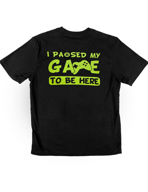 "I Paused My Game to be Here" neon meme t-shirt by Neon DripWear, showcasing vibrant UV-reactive colors and casual style.